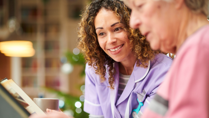 a nurse reading with an old lady 