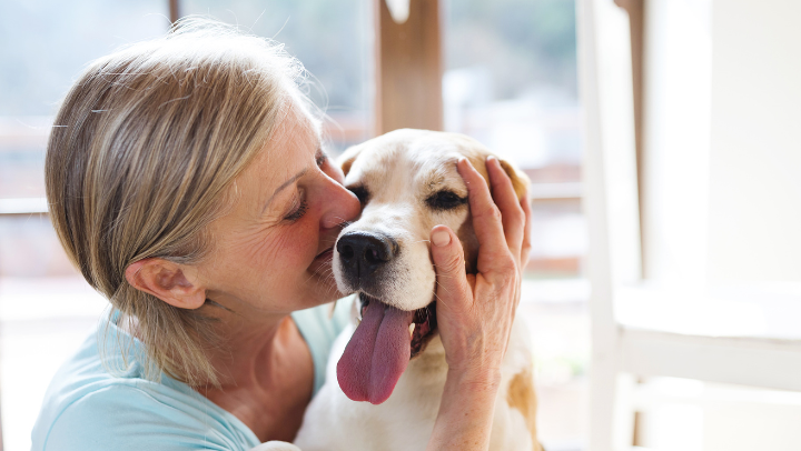 Old woman kissing a dog